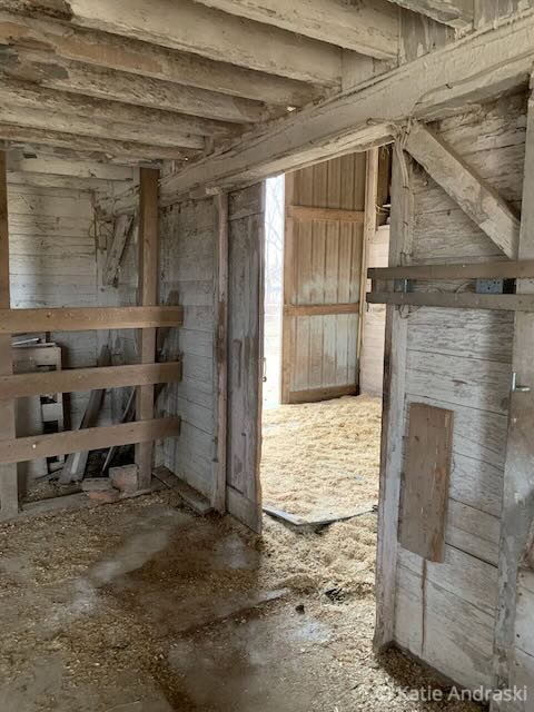 Interior of an old, rustic wooden barn with weathered walls and beams.