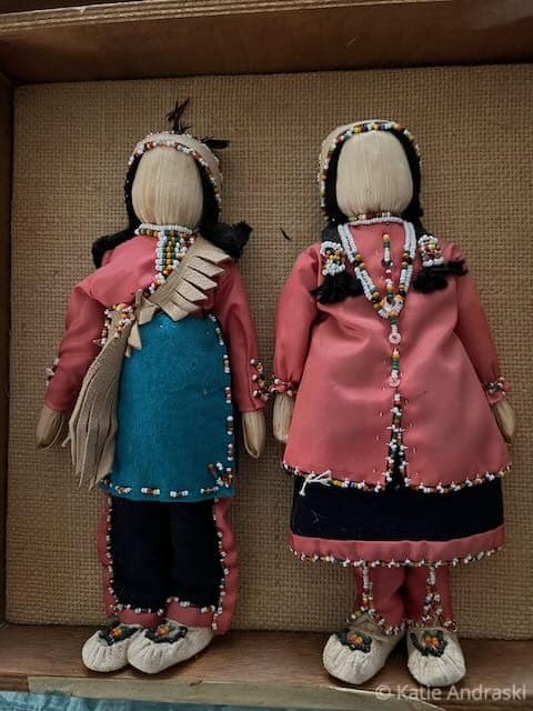 Two handcrafted fabric dolls dressed in colorful outfits, standing side by side.
