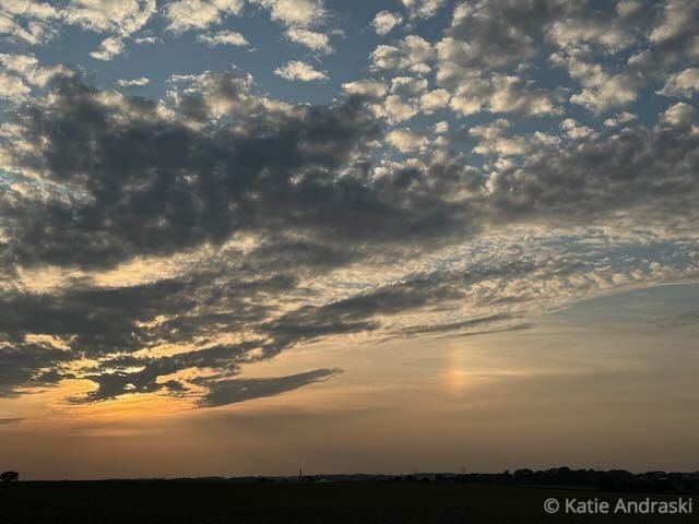 Sunset with dramatic clouds and a faint sun pillar in the sky.